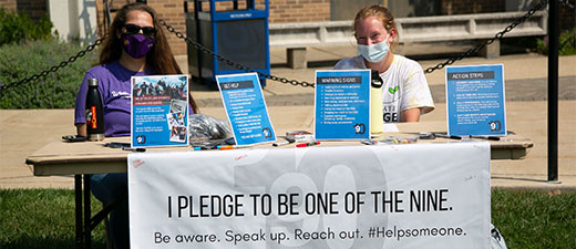 Resources thumbnail - 2 people sitting behind an information booth