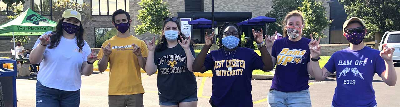 Senators are pictured on a sunny day outside of Sykes Student Union making a "Rams Up" with their hands after participating in community service