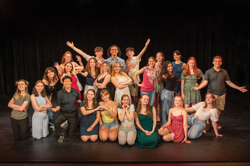 A group photo taken on a stage of theatre students