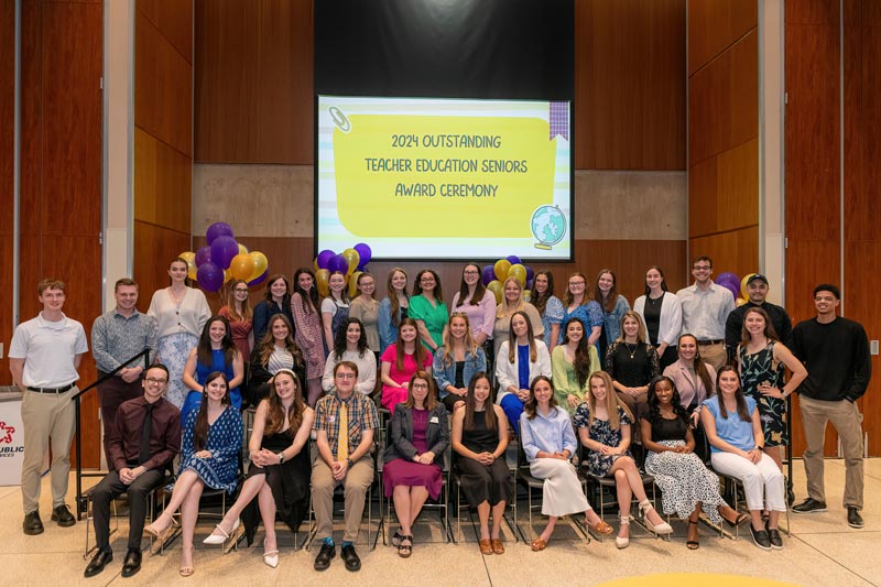 Banner" 2024 Outstanding Teacher Education Seniors Award Ceremony. Group of around 40 students sitting and standing for the group shot.