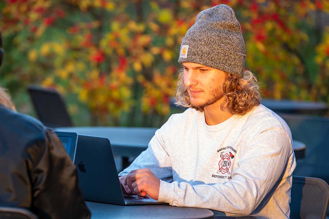 
						Student working on a laptop
					